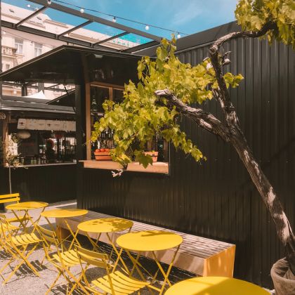 Restaurant patio with bright yellow tables and chairs